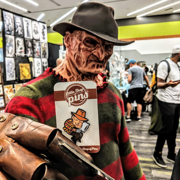 A person dressed up like Freddy is holding the pin of Freddy.