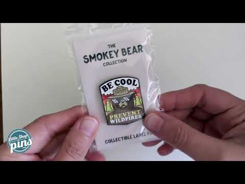 Video of smokey bear lapel pin being unwrapped and taken off backing card.