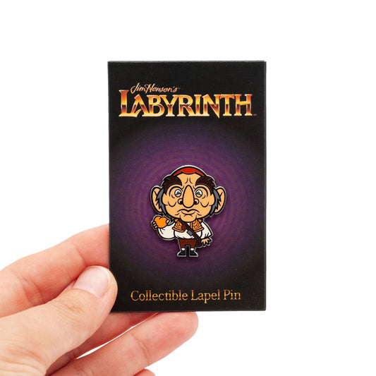 illustration turned into a pin for the character of Hoggle from Labyrinth. Colors include brown, tan, white, and orange for the peach he is holding. On a purple Labyrinth backing card.So cute!