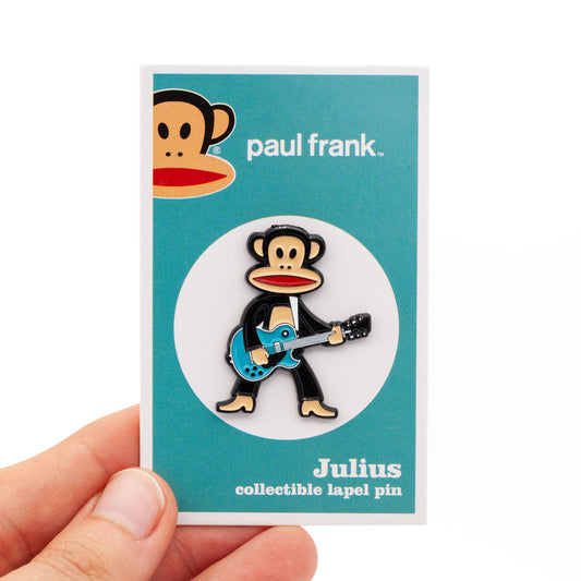Julius the monkey, playing a turquoise guitar, on backing card. 