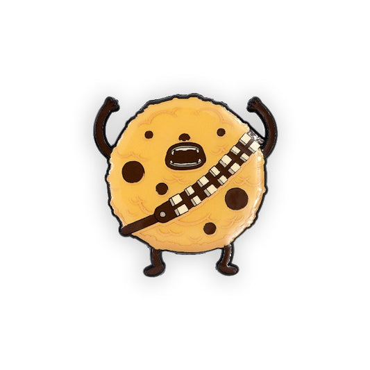 lapel pin that looks like a cookie but also chewie from star wars! he has his arms above his head. over white background.